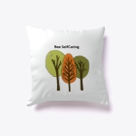 White cushion with illustration of three trees with differently coloured canopy. It says above in black writing "Bee SelfCaring"